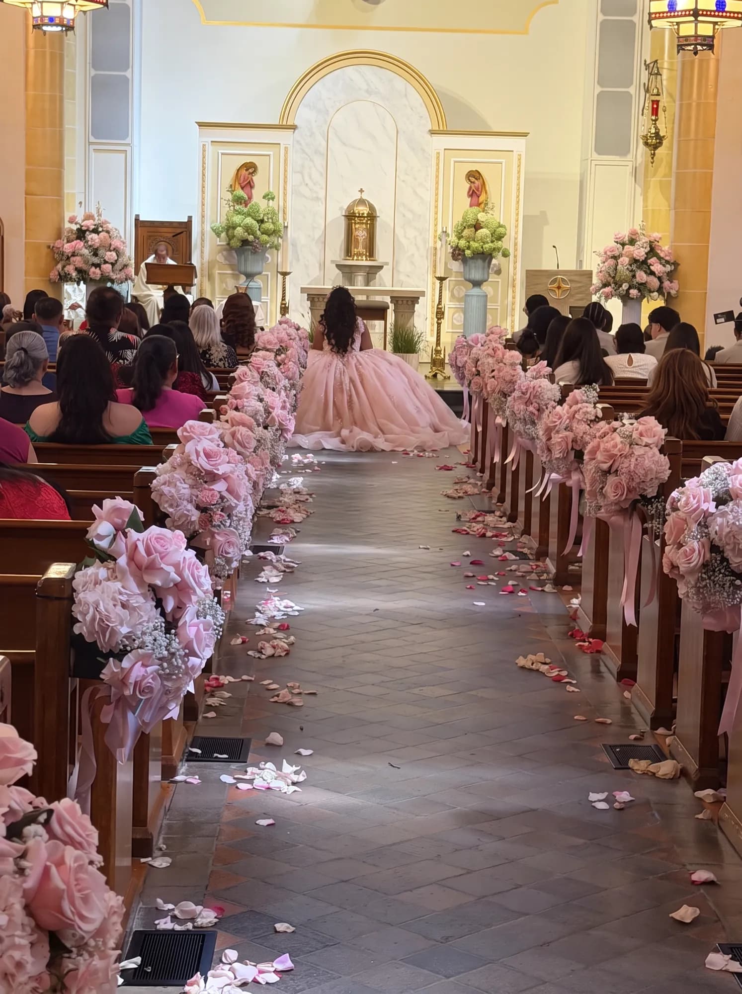 Quinceañera walking the rose-lined church aisle