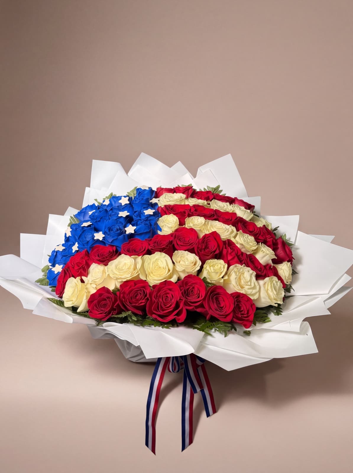 American flag bouquet of red, white, and blue roses wrapped in white paper