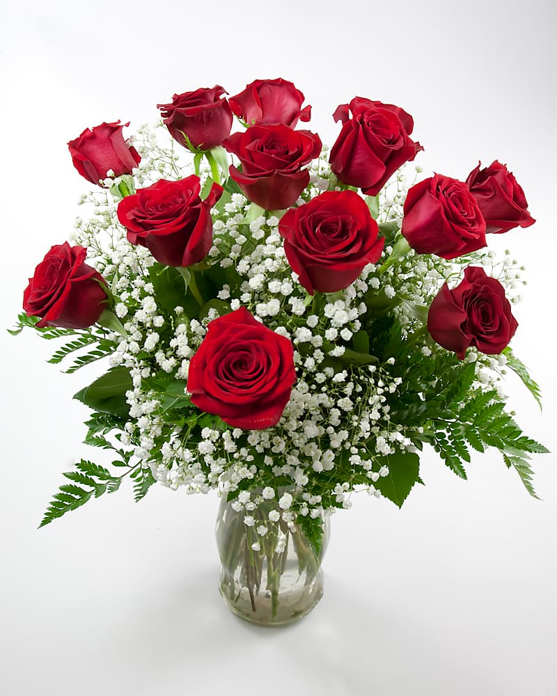 Dozen red roses arranged in glass vase