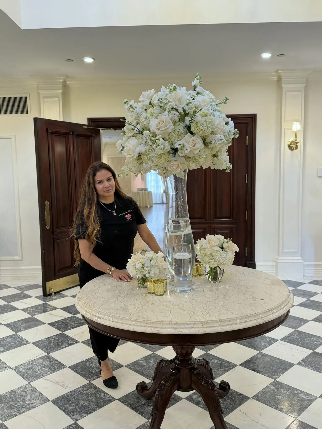 Maky, founder of Diva Flowers, beside a welcome arrangement at The Royalton Mansion