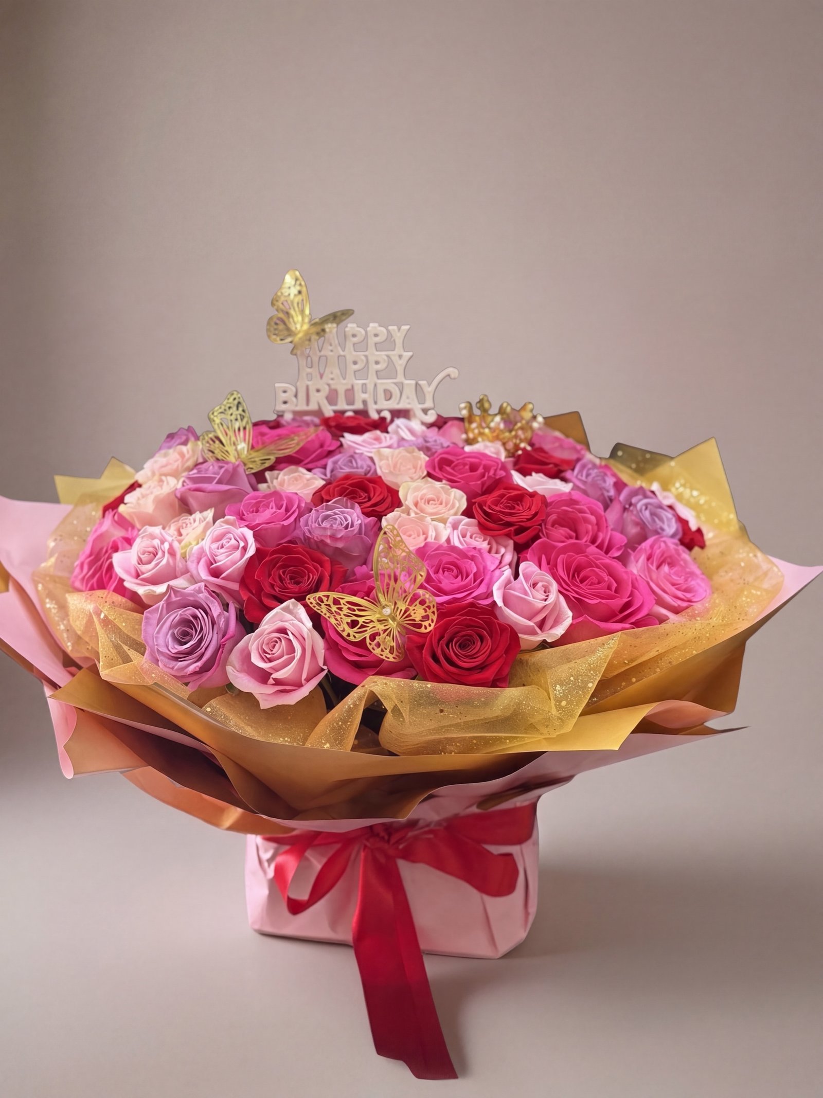 Sixty-rose birthday bouquet in pink and fuchsia with gold butterflies and a Happy Birthday topper in a pink box