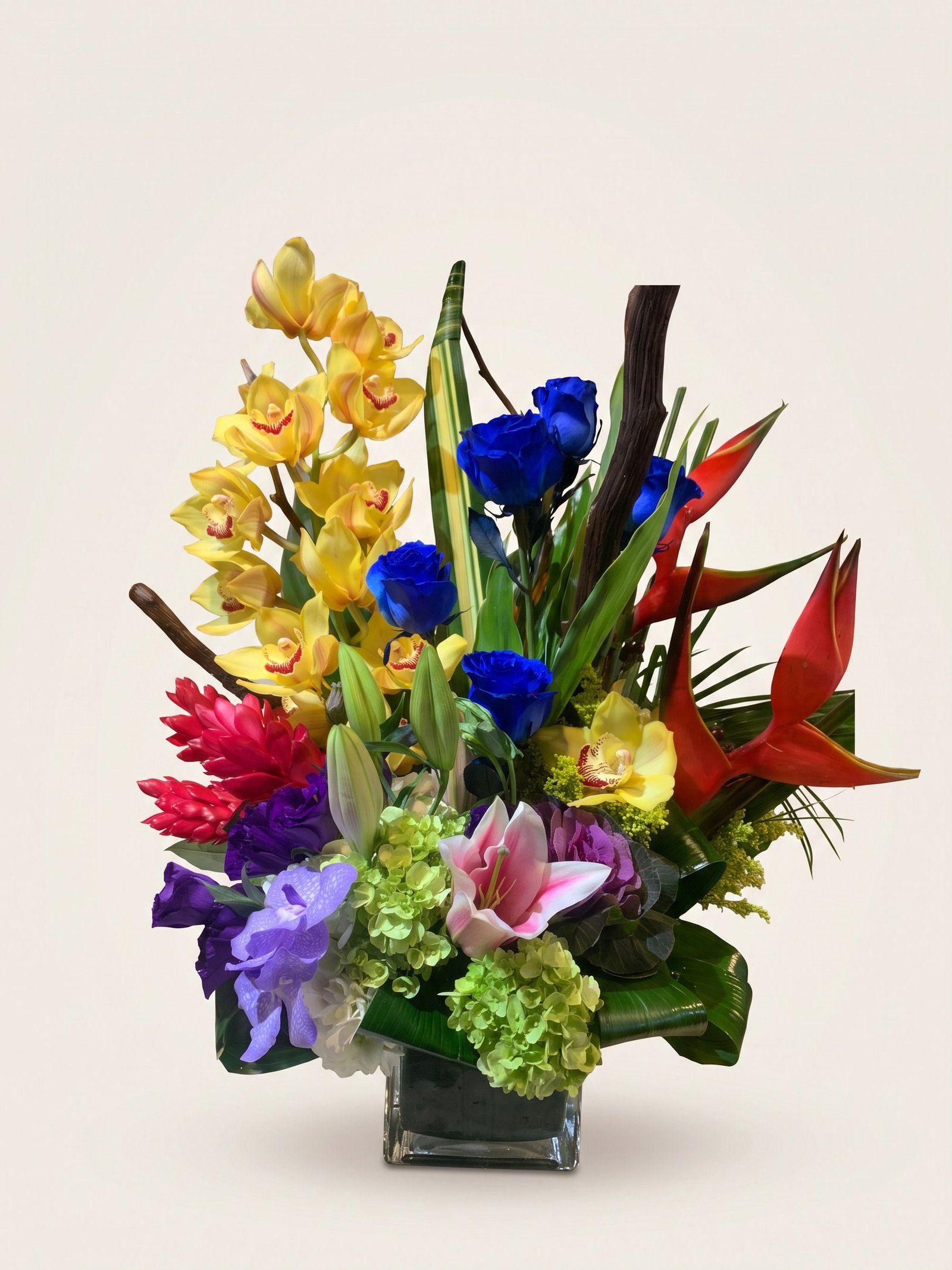 Arreglo exótico de orquídeas cymbidium amarillas, rosas azules, heliconia roja y ginger en cubo de vidrio