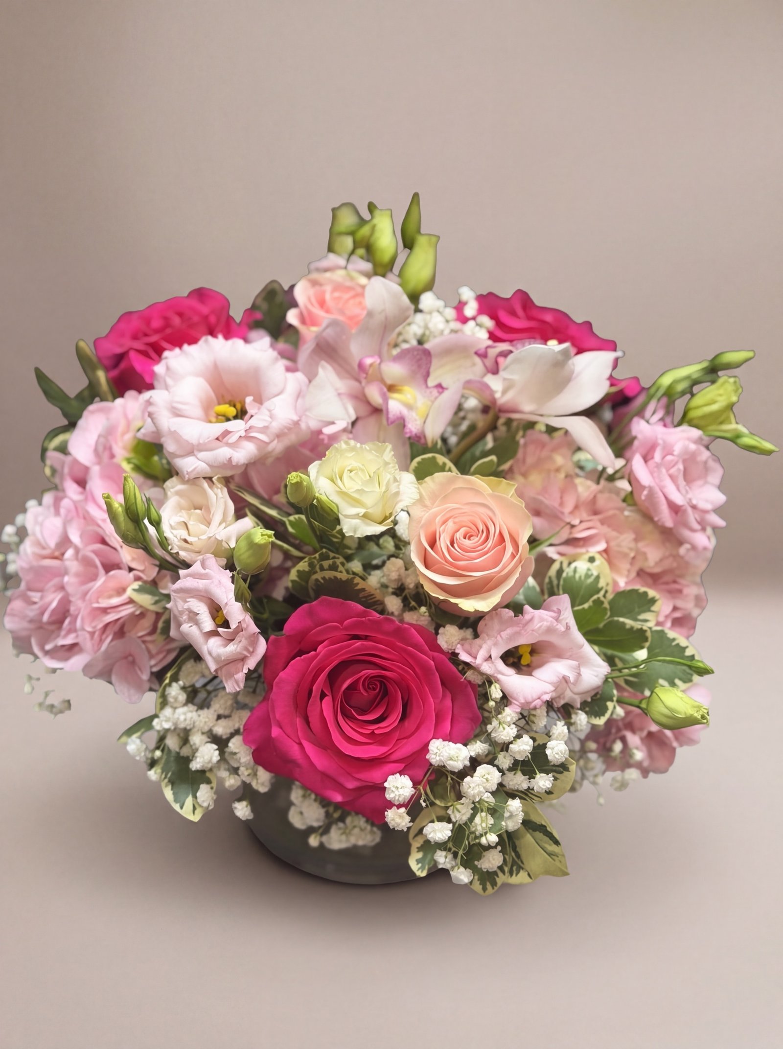 Rosas fucsia y durazno con paniculata y lisianthus blush en cuenco bajo