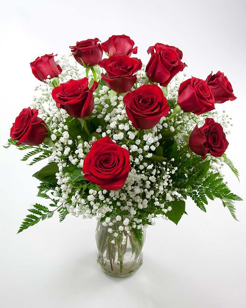 Dozen red roses arranged in glass vase
