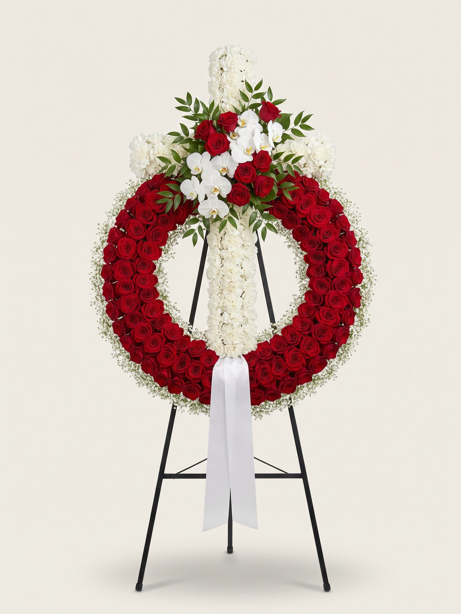Corona fúnebre en atril de rosas rojas con cruz de claveles blancos y orquídeas blancas
