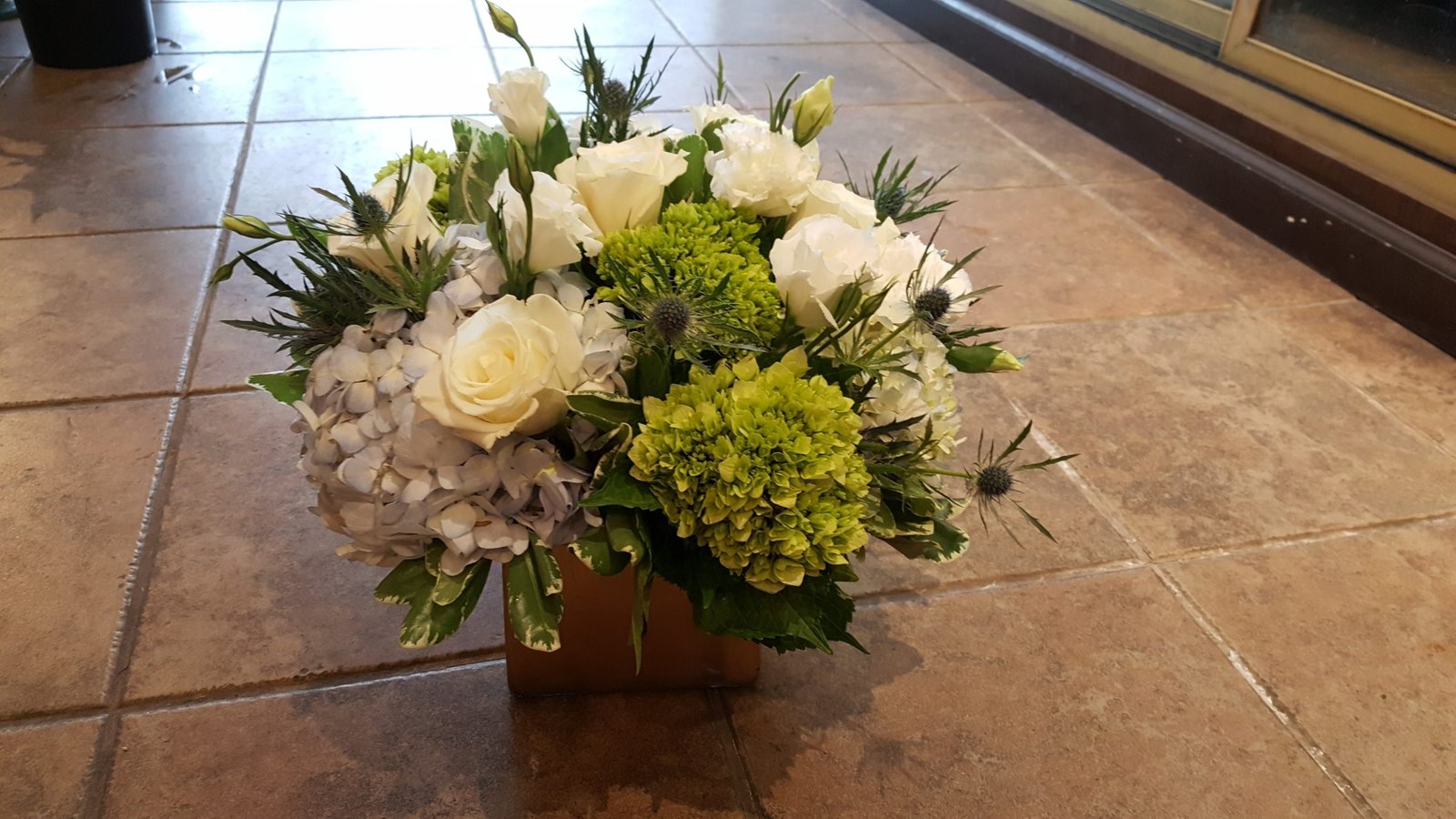 Winter Moss arrangement with cedar, moss, and white amaryllis